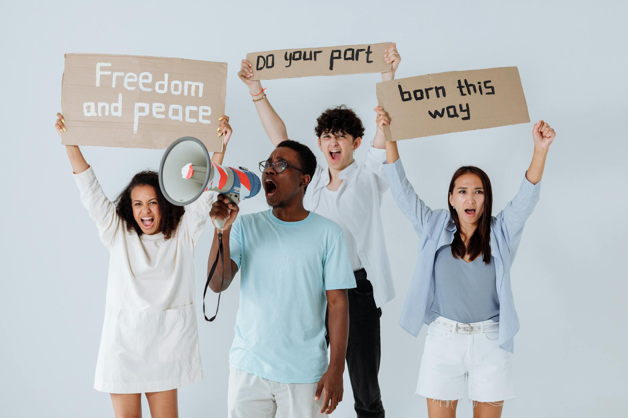 Diverse group of adults holding protest signs advocating for peace and equality.